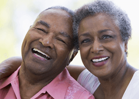 older black couple smiling at the camera