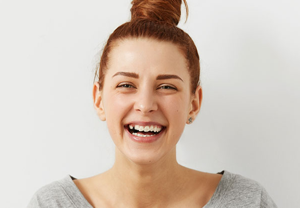 Young woman smiling with crooked teeth